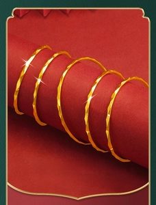 Macro detail of five gold-tone geometric faceted rings displayed on a red cylinder stand