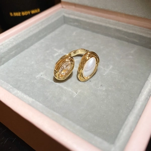 Detail of adjustable gold flower ring with teardrop zircon and pearl in a pink jewelry box