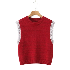 Red knit vest with round neck and white lace trim on wooden hanger over white background