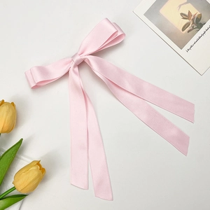 Detailed view of pink satin ribbon bow with long streamers and silk texture