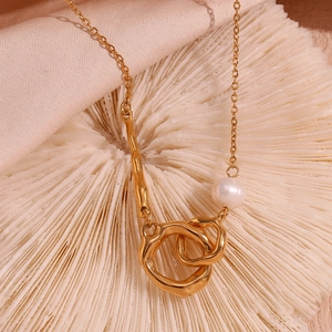 Détail du collier asymétrique plaqué or 18K avec perle et doubles anneaux entrelacés