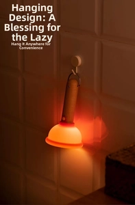 Detail of warm orange night light with cylindrical wood handle hanging on white tile wall