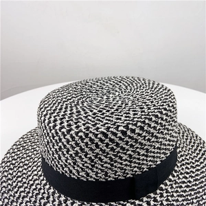 Detailed close-up of the black and white woven texture and ribbon on the boater straw hat