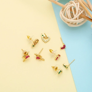 Flat lay of colorful gold zircon earrings in heart star and teardrop shapes