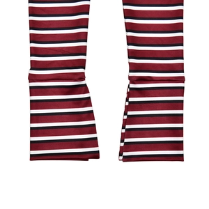 Close-up of striped flared pants hem featuring red, black, and white horizontal patterns