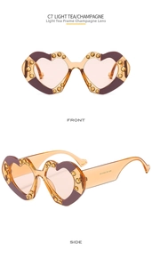 Detail of heart-shaped sunglasses with light tea frame, champagne lenses and rhinestones