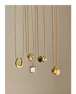 Close-up of assorted gold titanium steel pendants including horseshoe and heart shapes