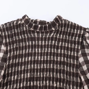 Detail of honeycomb plaid fabric featuring elastic smocked texture and neckline texture