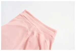 Macro shot of flatlock stitching and high-waist details on pink yoga leggings