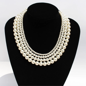 Elegant four-layer creamy white pearl necklace displayed on a black velvet neck bust