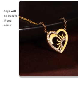 Détail du collier pendentif coeur doré avec motifs ajourés soleil lune et zircons