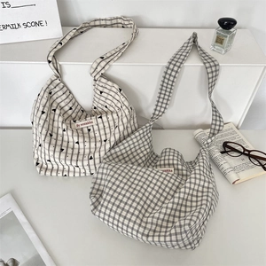 Flat lay of canvas tote bags in striped and checkered patterns on a white display