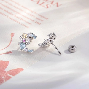 Silver bow and crescent moon stud earrings with blue heart zircon and pink stones