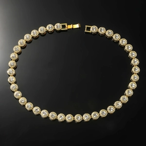 Detailed macro view of a gold-toned hip hop tennis necklace with round crystal clusters