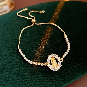 Détail du bracelet doré ajustable Vierge Marie orné de zircons et fermoir coulissant bolo