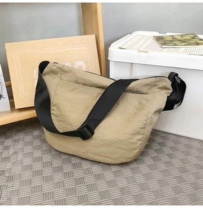 Detail view of khaki nylon dumpling bag with adjustable wide black shoulder strap