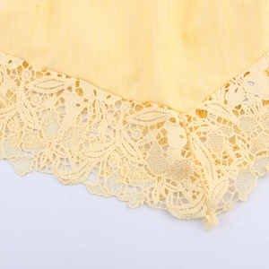 Elegant yellow sleeveless top with intricate lace hem and textured linen-like fabric detail
