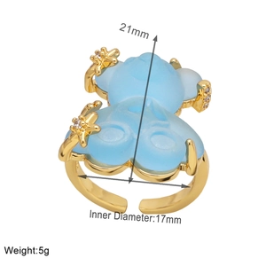 Detail view of adjustable gold-plated ring featuring blue resin bear and zircon star charms