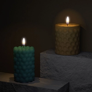 Modern bubble and honeycomb pillar candles burning on rock pedestal for home decor