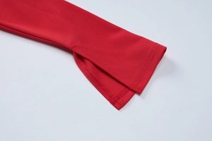 Détail du poignet d'une robe rouge avec fente élégante et coutures de précision soignées