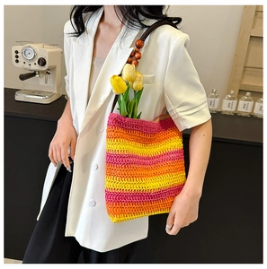Detail of colorful gradient straw tote bag with beaded handle and floral decoration