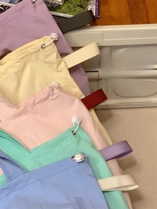 Detail of colorful nylon drawstring tote bags with contrast handles and plastic toggles