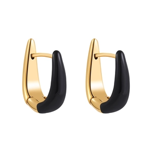 Detail of gold U-shaped earrings with black enamel finish on a white background