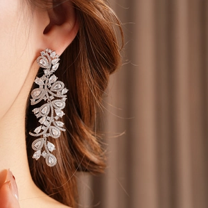 Boucles d'oreilles feuilles en argent avec glands en zircone, détail chic sur modèle