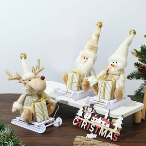 Golden knit Christmas dolls featuring Santa, reindeer, and snowman on sleigh bases