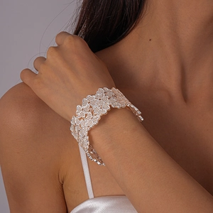 Détail du bracelet manchette argenté ajouré avec motifs complexes de fleurs et de cœurs