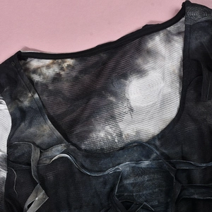 Detail of sheer mesh tie-dye fabric featuring a round neckline with subtle edge binding