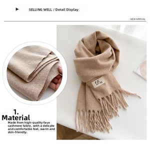 Close-up of soft beige cashmere-like scarf fabric texture with decorative fringe detail
