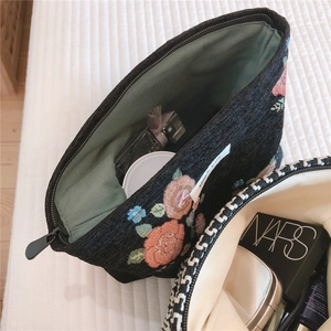 Detail of floral embroidery and woven texture on large capacity vintage makeup bags