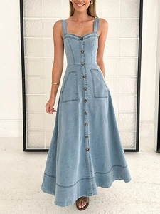 Dettaglio dell'abito lungo in denim con abbottonatura argentata e grandi tasche applicate