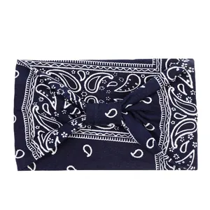 Detail of navy blue paisley sweatband showing soft knitted fabric texture and twisted knot