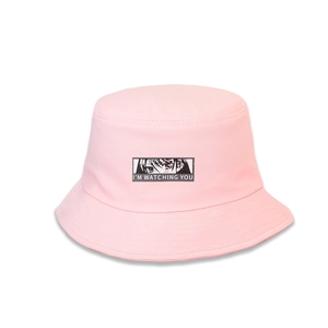 Detail of a pink bucket hat showing the 'I'M WATCHING YOU' print and high-density stitching