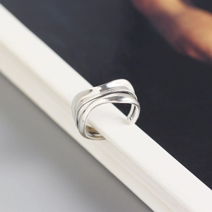 Macro shot of minimalist silver double-layer wavy ring on a book edge for women