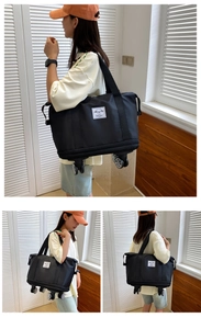 Close-up of a black oxford travel bag with universal wheels and expandable bottom design