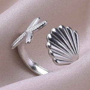 Detailed macro shot of adjustable stainless steel starfish and seashell open ring
