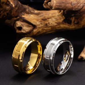 Detailed macro view of gold and silver brushed titanium rings with geometric cut on wood
