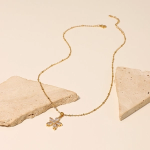 Macro detail of 18K gold plated flower pendant with sparkling white zircon stones