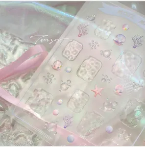 Macro detail of 3D ocean nail art stickers with embossed shells and water ripples