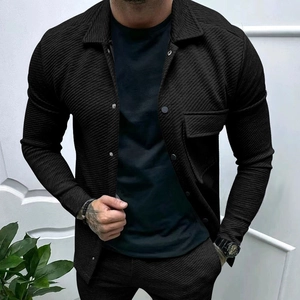 Detail of black twill textured shirt jacket featuring metal buttons and flap pocket