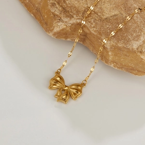Macro shot of gold bow pendant with twisted chain on a stone for a luxurious look