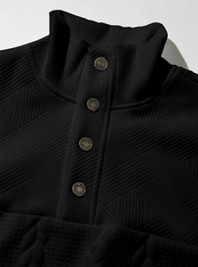 Detail of black knit sweatshirt featuring bronze buttons and intricate textured patterns