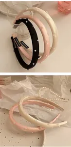 Detail of handmade satin headbands with pearl accents and a vintage-style woven label