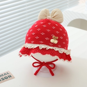 Detail der roten Baby-Strickmütze mit Herzbestickung und beiger Schleife