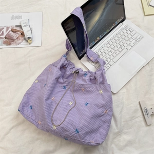 Dettaglio della borsa a tracolla scozzese lavanda con fiocco ricamato e cordoncino