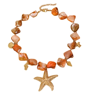 Dettaglio del bracciale con conchiglie stile marino e ciondoli a stella marina oro