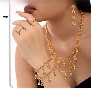 Detail view of golden bohemian jewelry set featuring spiral swirl pendants and tassels